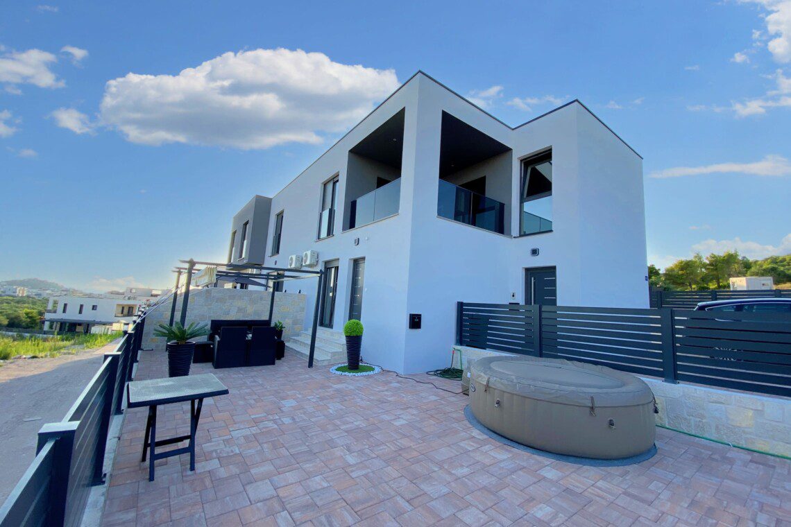 Contemporary white building surrounded by lush greenery, perfect for a luxurious vacation rental experience.
