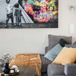 Cozy living room adorned with vibrant street art poster, perfect for an urban getaway experience